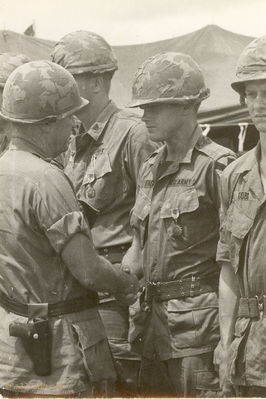 Lee King
Guy Sparrow Photo

The officer giving the award is Gen J.J.Tolson. From Jay Dirnberger: "I recognize the man giving Lee King his Air Medal as Major General John Tolson, 1st Cavalry Division Commander. I was one of his Aides de Camp at Fort Bragg, where he later was the Corps Commander of the 18th Airborne Corps."

To the right of Lee is Aaron Cobb who was the cook for A/227. The Warrent Officer on Lee's left is unknown.


